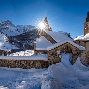 La Grave, Hautes-Alpes, Ecrins National Park, Alps, France: The local village of La Grave and its church with La Meije mountain peak in winter